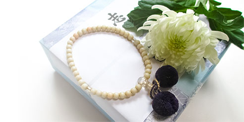 白い菊と数珠と返礼品