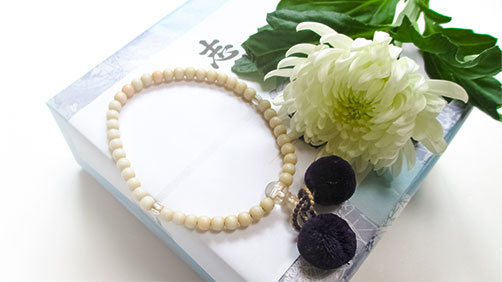 白い菊の花と数珠と返礼品