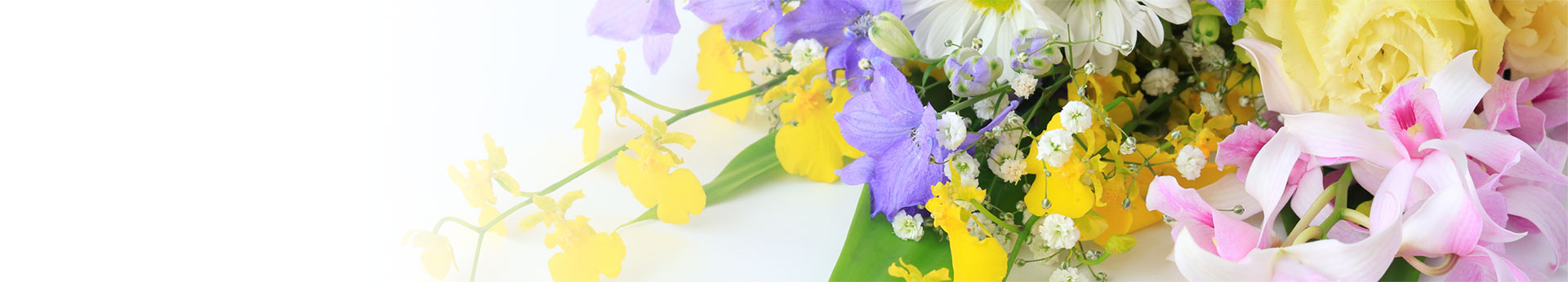 カラフルな花々があしらわれた花束を背景にしたその他の葬儀ページのトップバナー