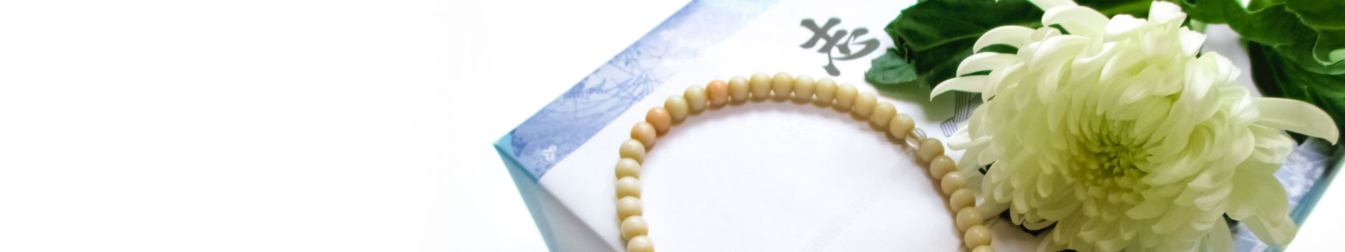 白い菊の花と数珠と返礼品を背景にした返礼品ページのトップバナー